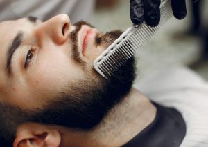 man getting beard trimmed at barber shop
