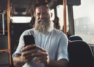 bald man with bushy beard reads texts