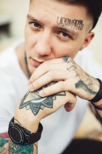 man with tattoo on face and hands