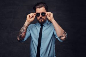 man with arm tattoos and sunglasses