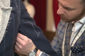 custom tailor pins scrap jacket on client