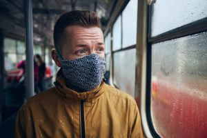 man on train wears patterned face mask