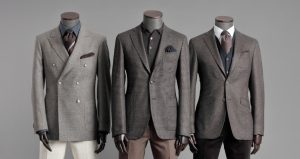 three mannequins in a row wearing brown suits