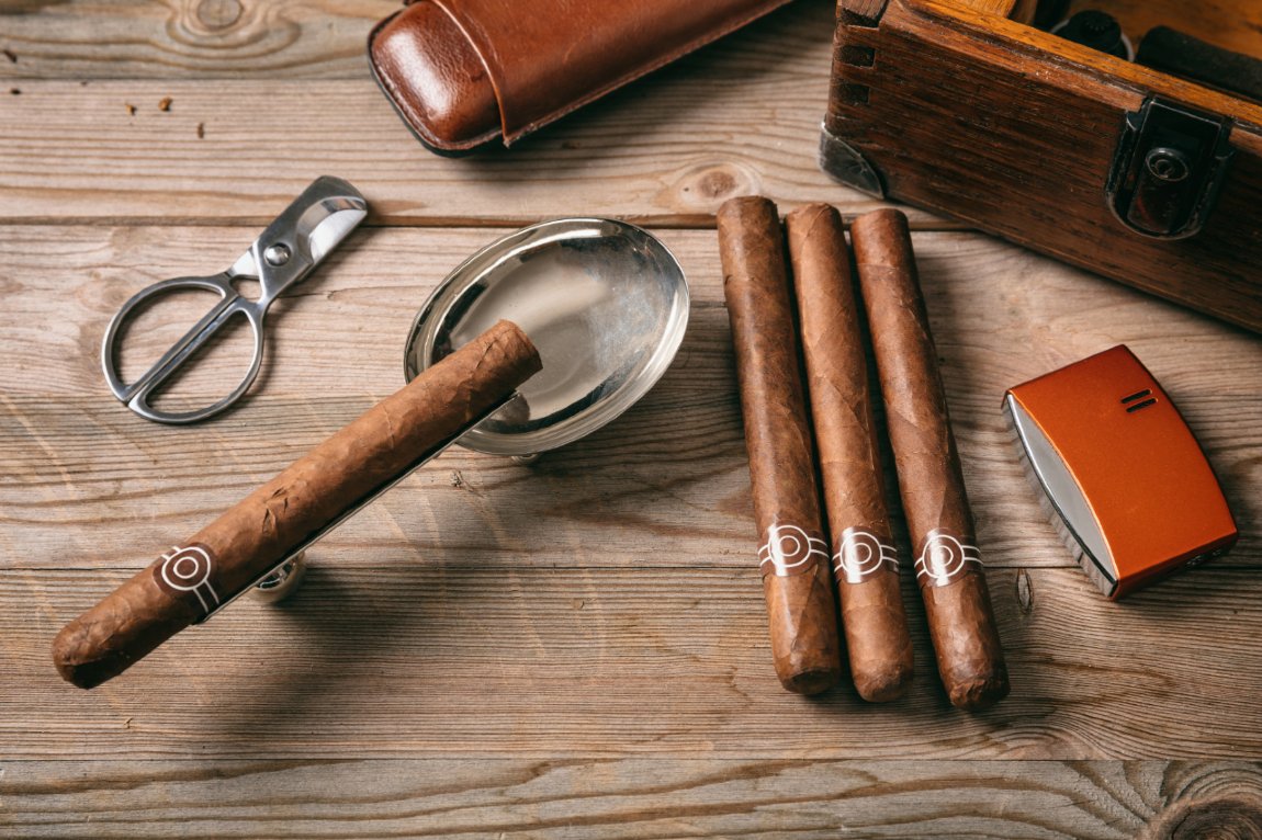 four cigars on a wooden table