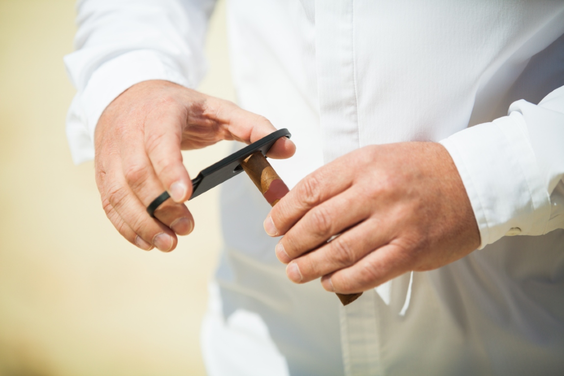 man cutting a cigar