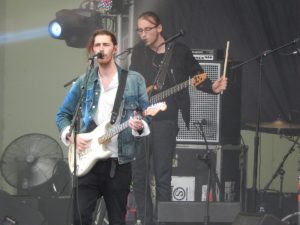 two men perform music on stage